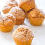 Mini pumpkin muffins over a white background.