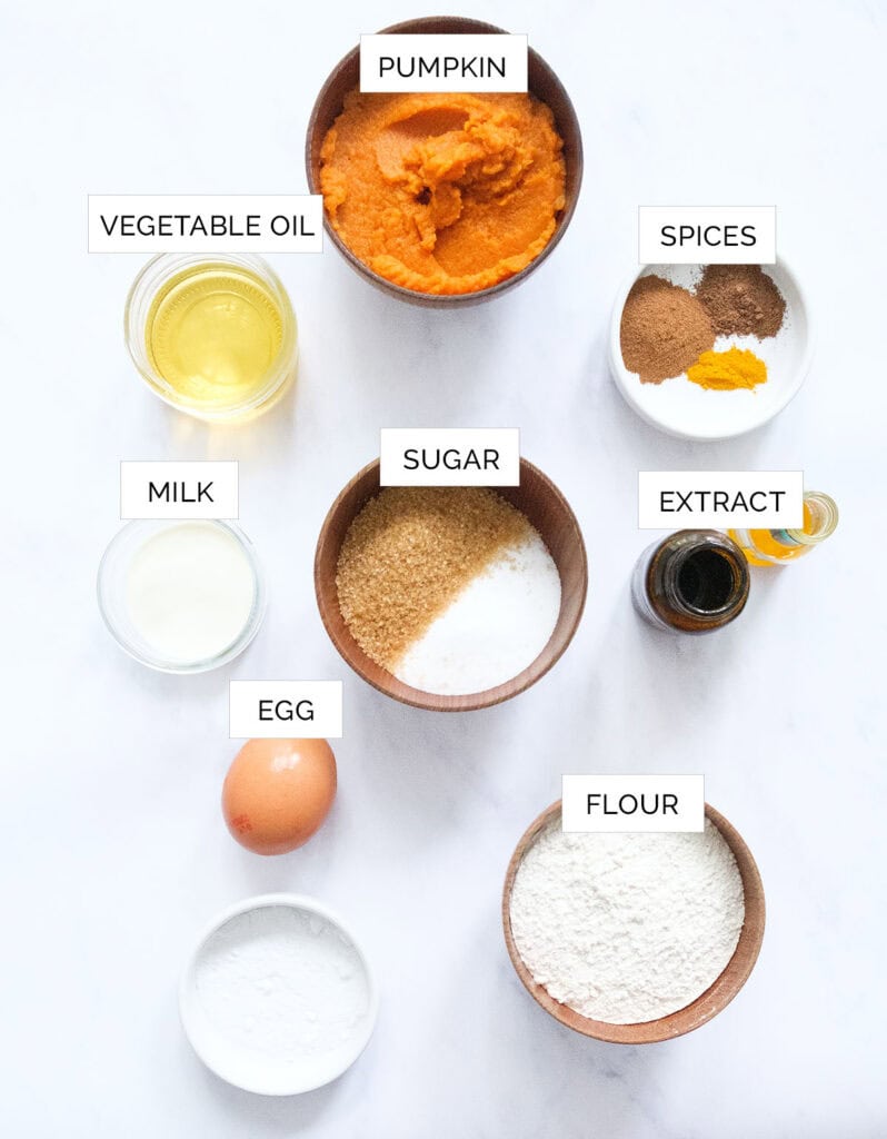 The ingredients to make mini pumpkin muffins are arranged over a white background,