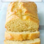 A healthy yogurt cake loaf cut into slices over a light blue background.