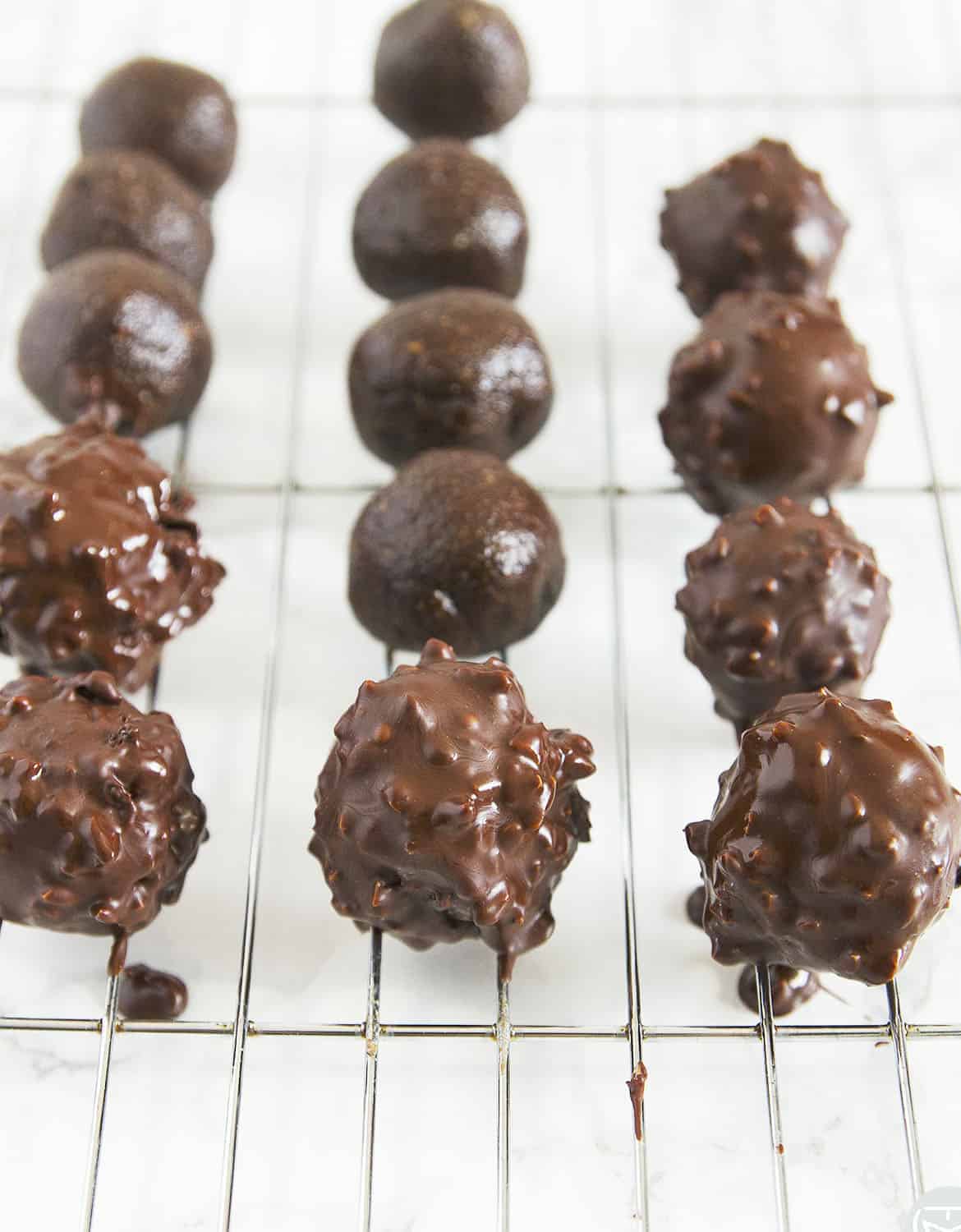 Coat the homemade Ferrero Rocher truffles in melted chocolate and chopped hazelnuts for a delicious finishing touch.