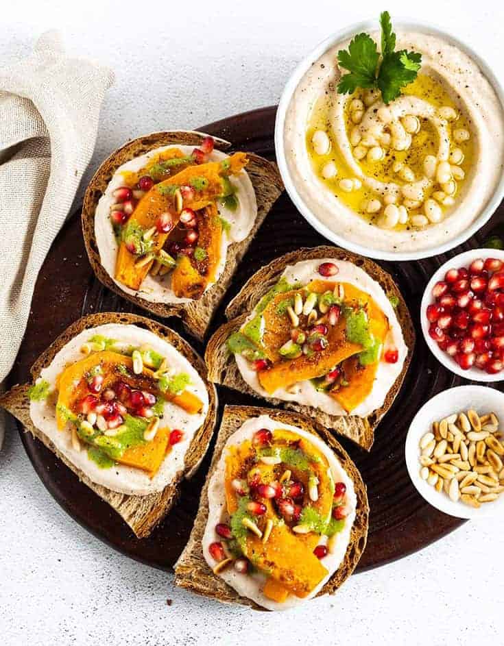 Assortment of vegan appetizers on a black round tray.