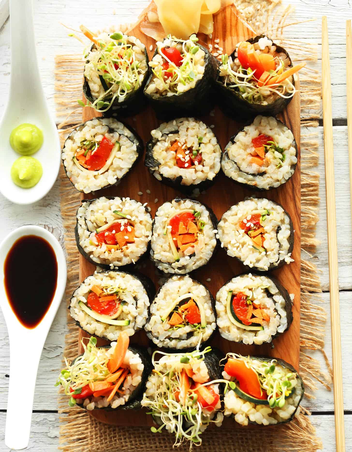 15 veggie rice sushi rolls on a rectangular wooden board - Minimalist Baker