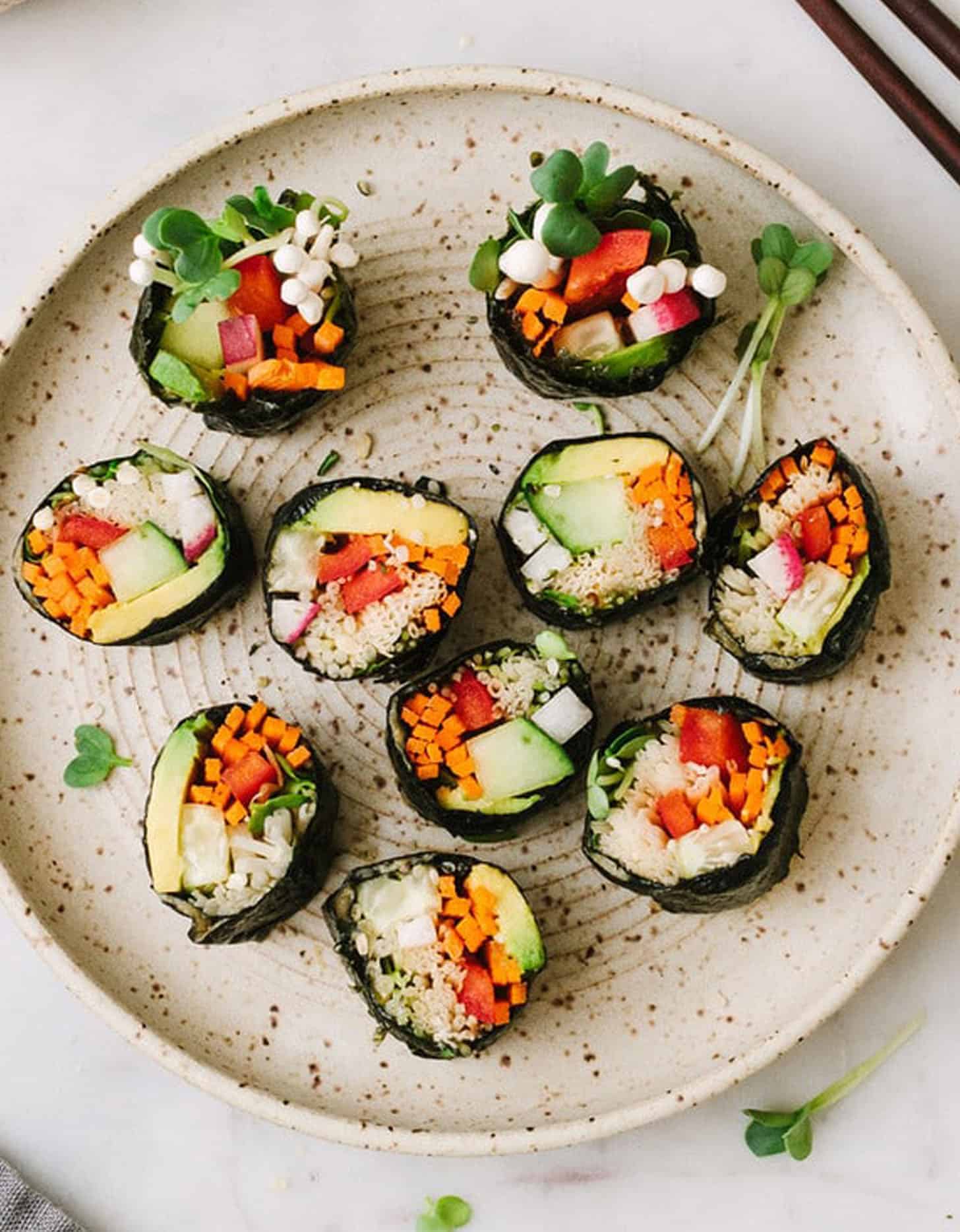 10 raw vegan sushi rolls on a grey plate - The Simple Veganista