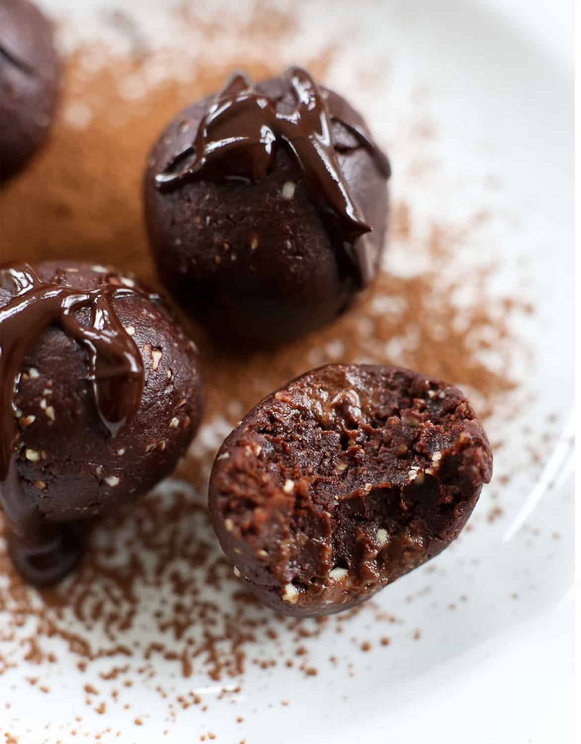 Close-up of  moist chocolate bliss balls decorated with melted chocolate over a white plate - Happy Healthy Mama