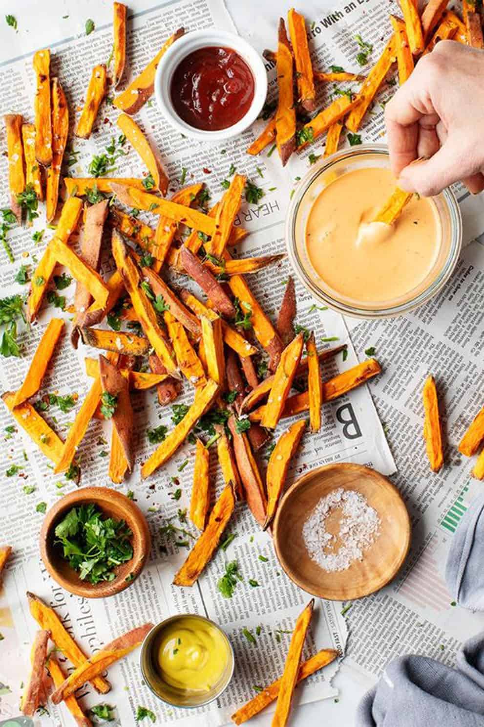 Crispy baked sweet potato fries over newspaper sheets - Love and Lemons