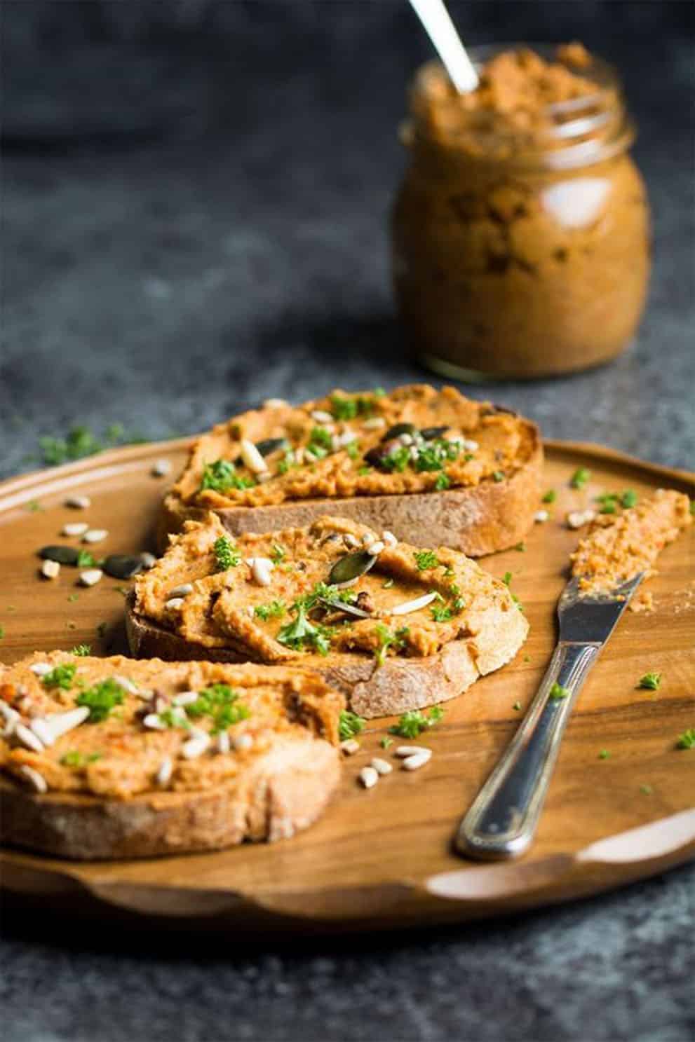 Slices of bread with vegan pate' on a round wooden plate - Lauren Caris Cooks