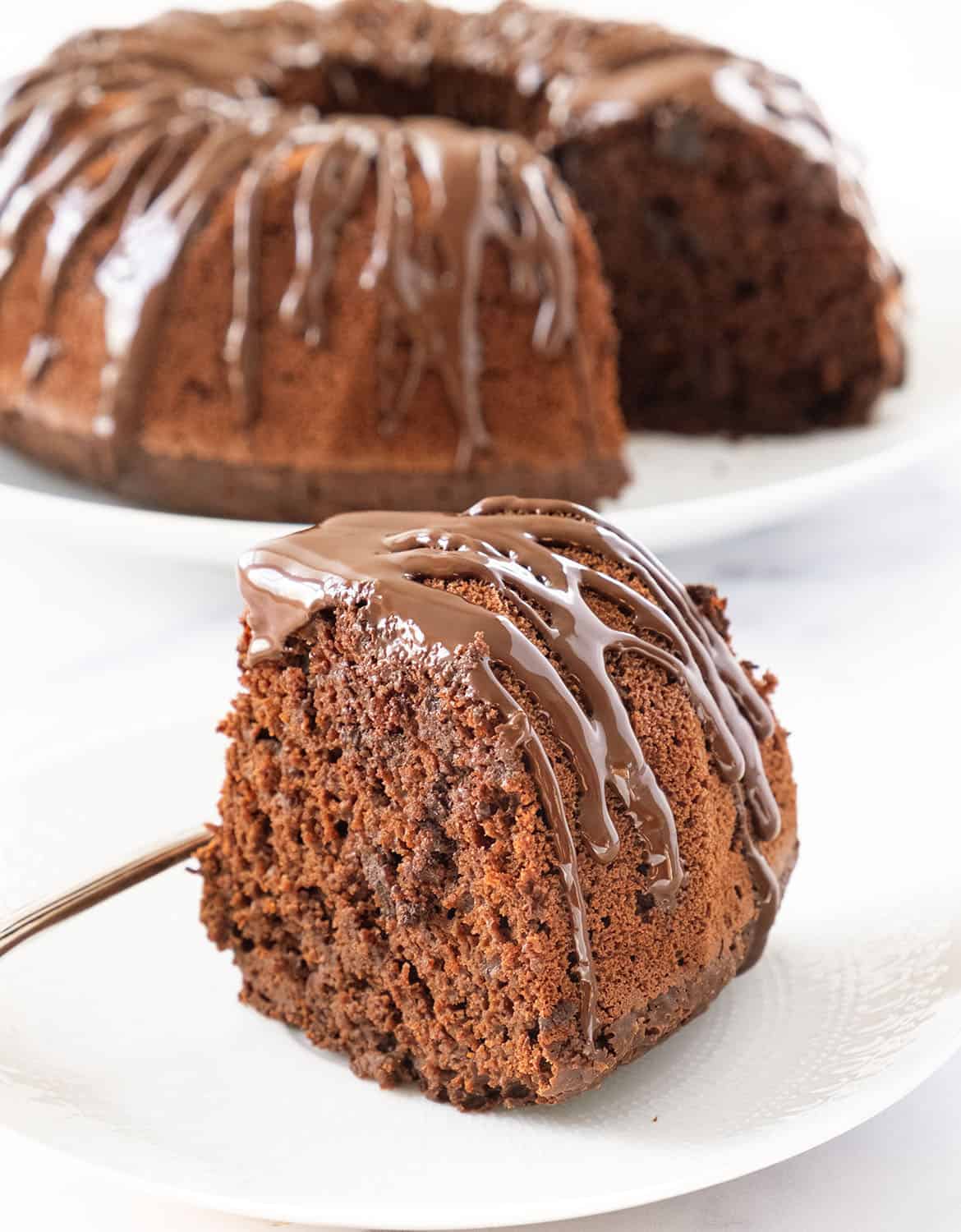 Close-up of a vegan chocolate bundt cake over a white background.