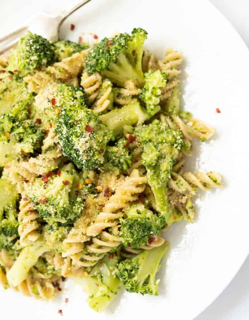Broccoli pasta with toasted breadcrumbs on a white plate.