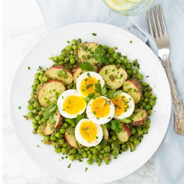This is a delicious potato and egg salad with peas super easy to throw together, you need just a few basic and inexpensive ingredients like potatoes, eggs, frozen peas and fresh herbs.  And not only is it perfect for a picnic, but it makes a nice and healthy lunch all year round.