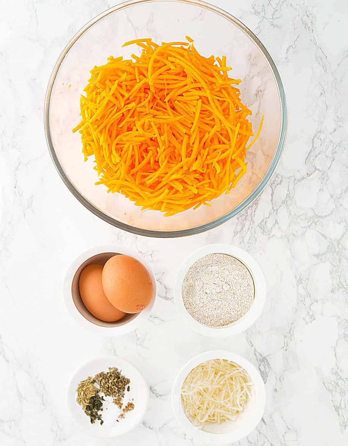 The ingredients for the butternut squash fritters are arranged over a white background.