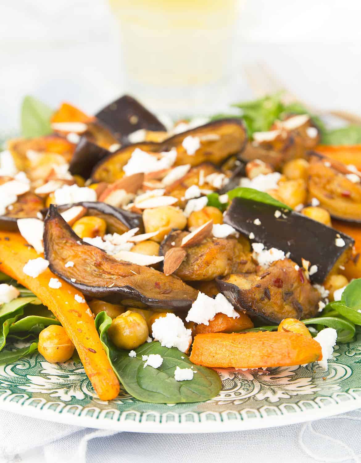 Close-up of harissa eggplant and carrot salad with feta and almond slices.