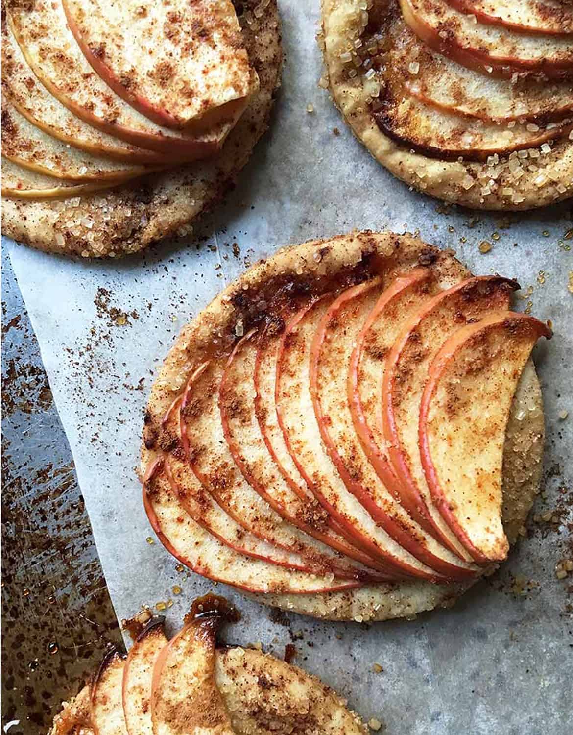 Rustic apple tartlets over parchment paper - Foodal