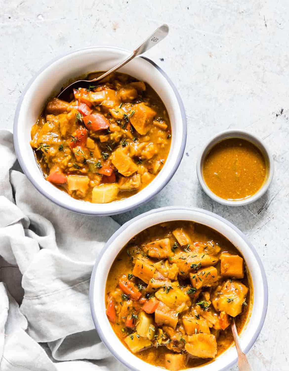 Two bowls of pumpkin curry over a light grey background - Recipes from a Pantry