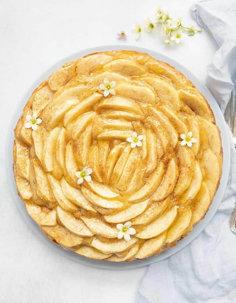 A beautiful apple cake decorated with small flowers.