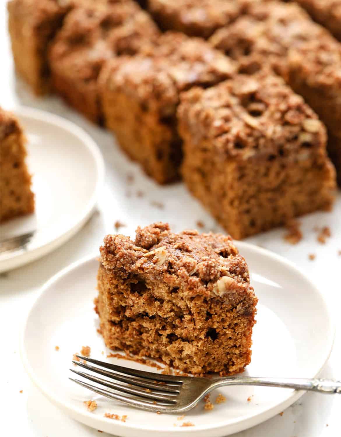 A portion of coffee cake on a white plate with a fork - Simply Quinoa