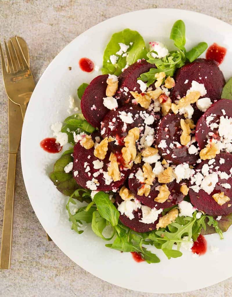 Beetroot salad with feta over a white serving plate.