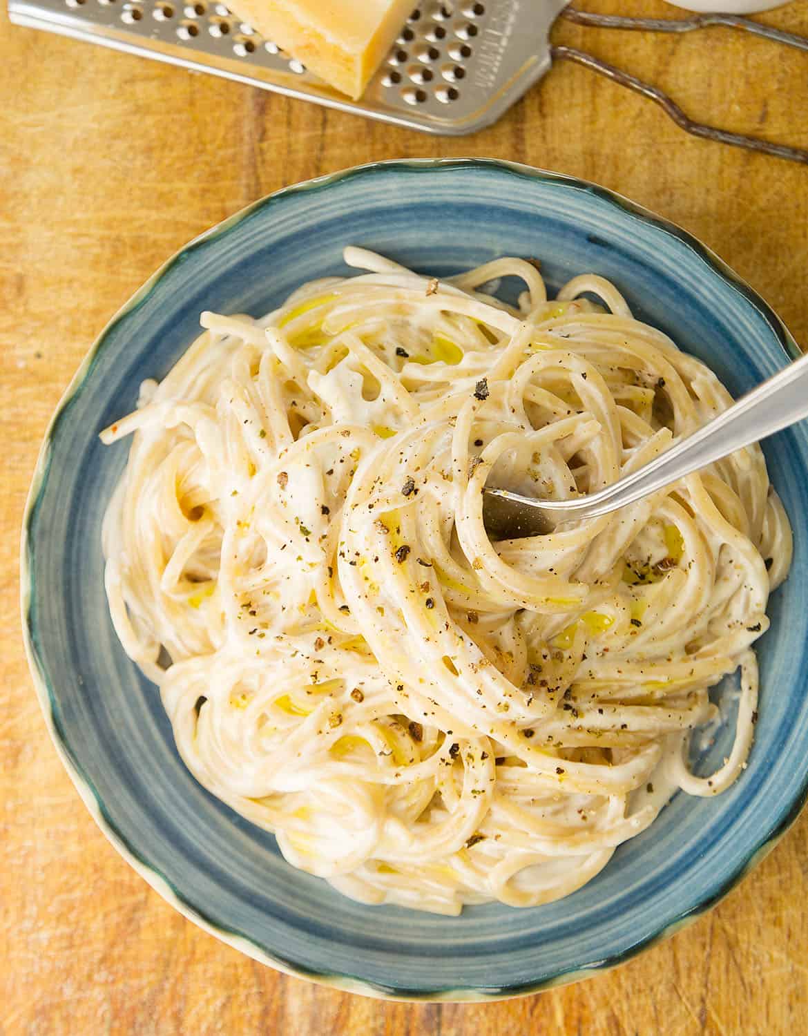 A portion of delicious cream cheese spaghetti on a blu plate