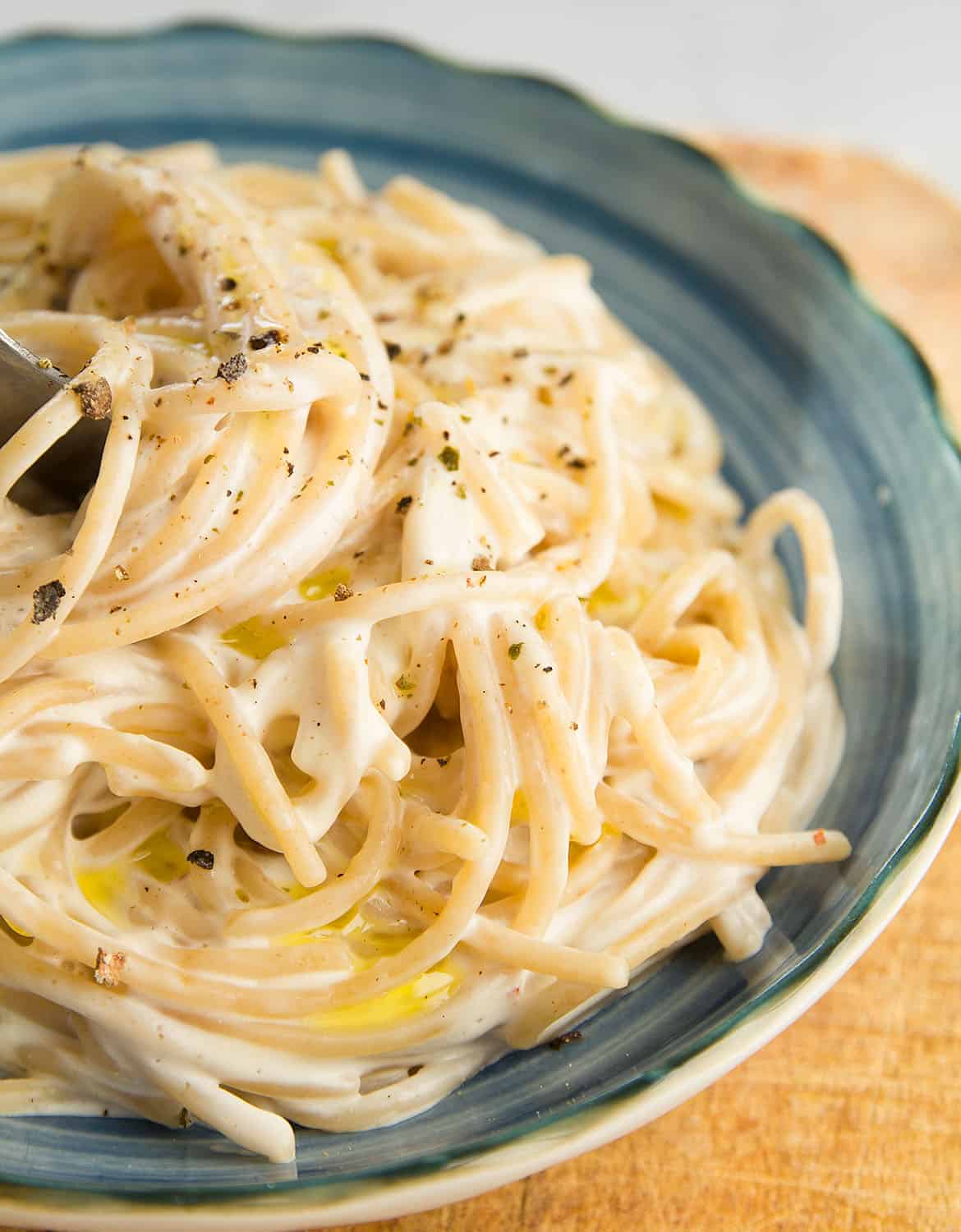 A portion of easy cream cheese pasta on a blue plate.