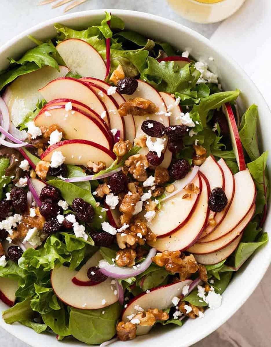 Holiday apple salad with candied walnuts and cranberries in a white bowl - Recipe Tin Eats