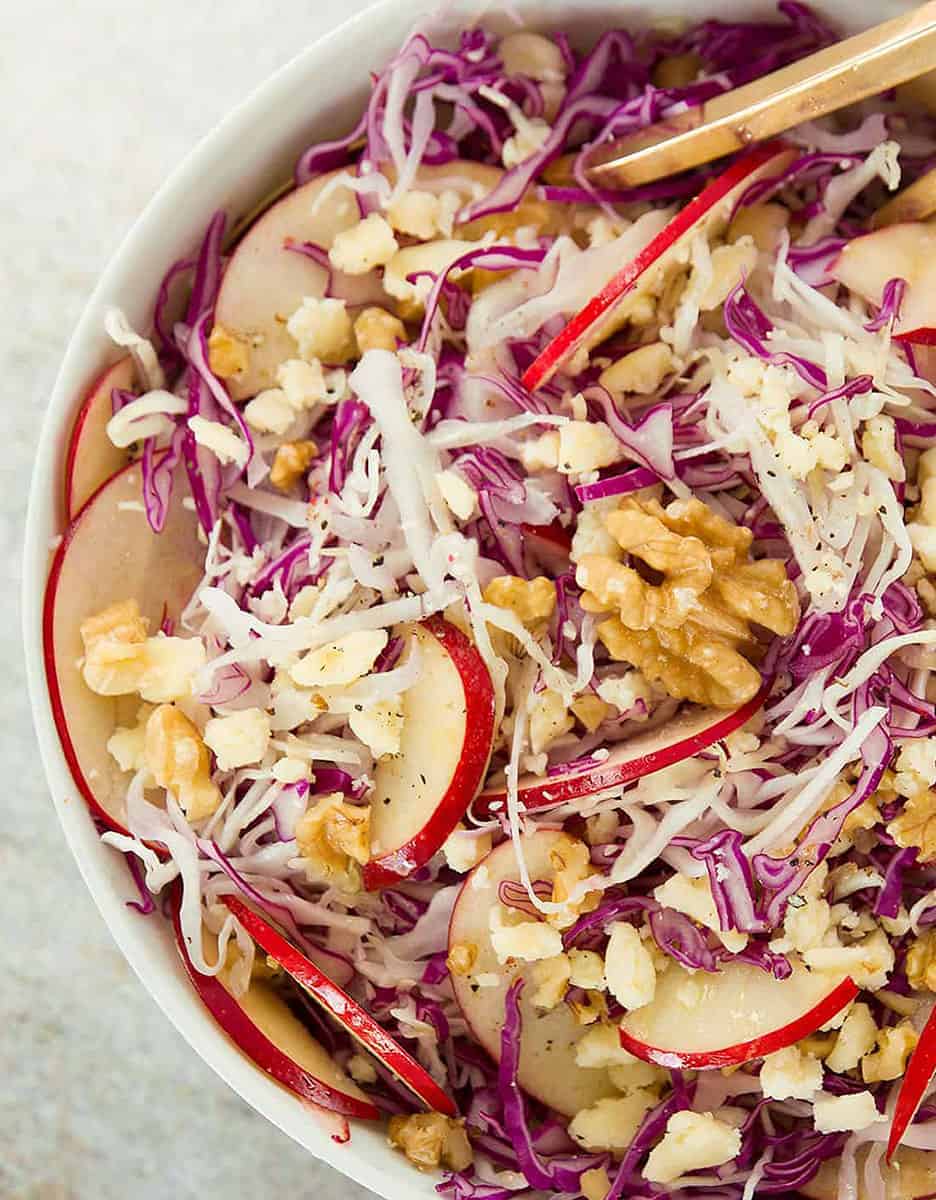 Cabbage salad with apples and walnuts in a large white bowl - The Clever Meal
