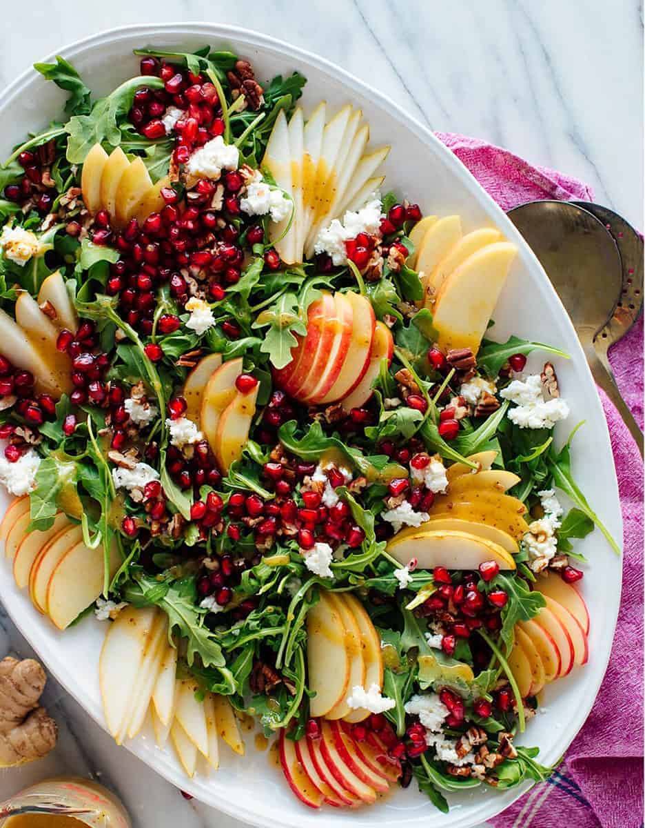 Festive pomegranate & pear green salad with pomegranate on a white serving plate - Cookie & Katie