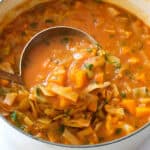 A white pot full of vegetarian cabbage soup.