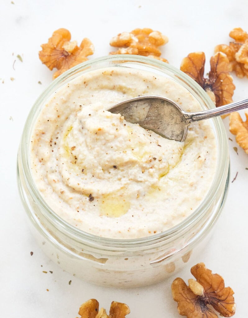 Close-up of a glass jar full of walnut pesto.