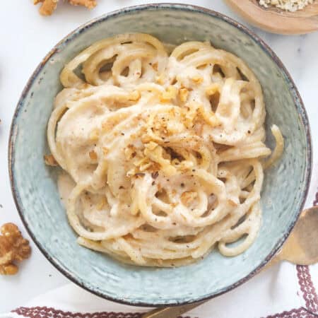 Top view of a bowl full of pasta with walnut pesto.