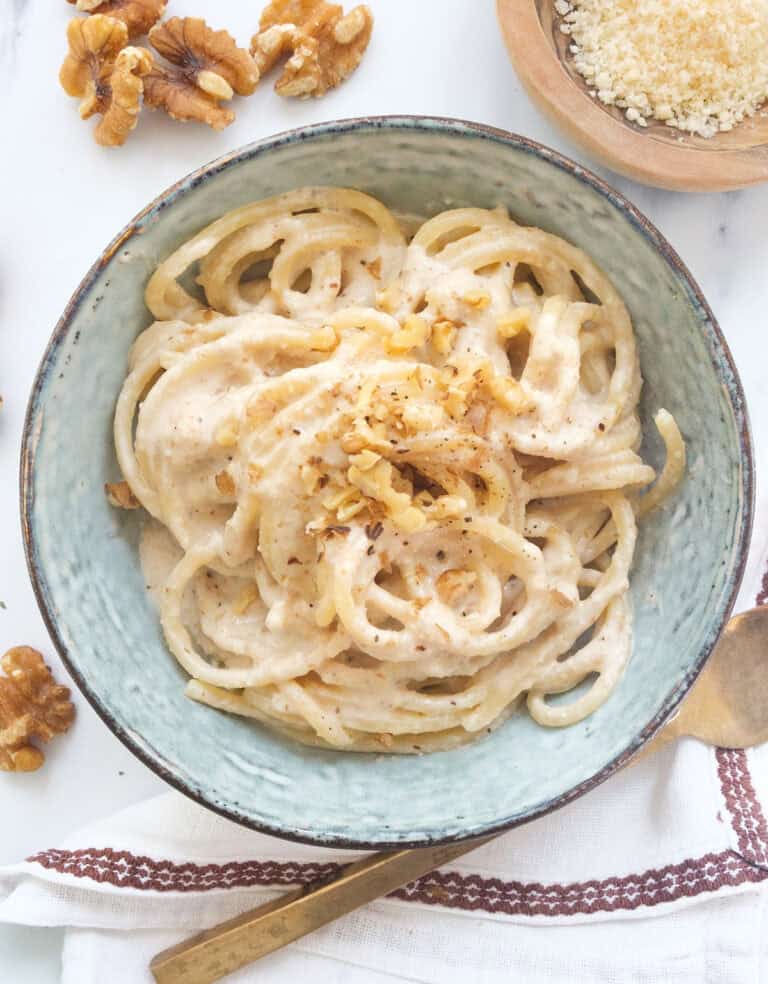 Top view of a bowl full of pasta with walnut pesto.