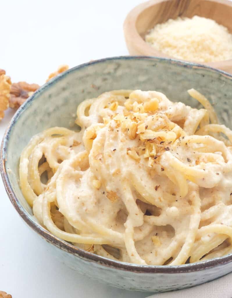 Close-up of a bowl full of spaghetti with walnut pesto.
