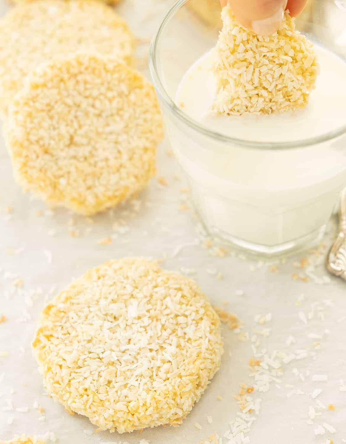 Coconut cookies and a glass of milk over a white background.