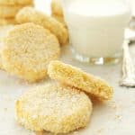 Coconut cookies and a glass of milk over a white background.