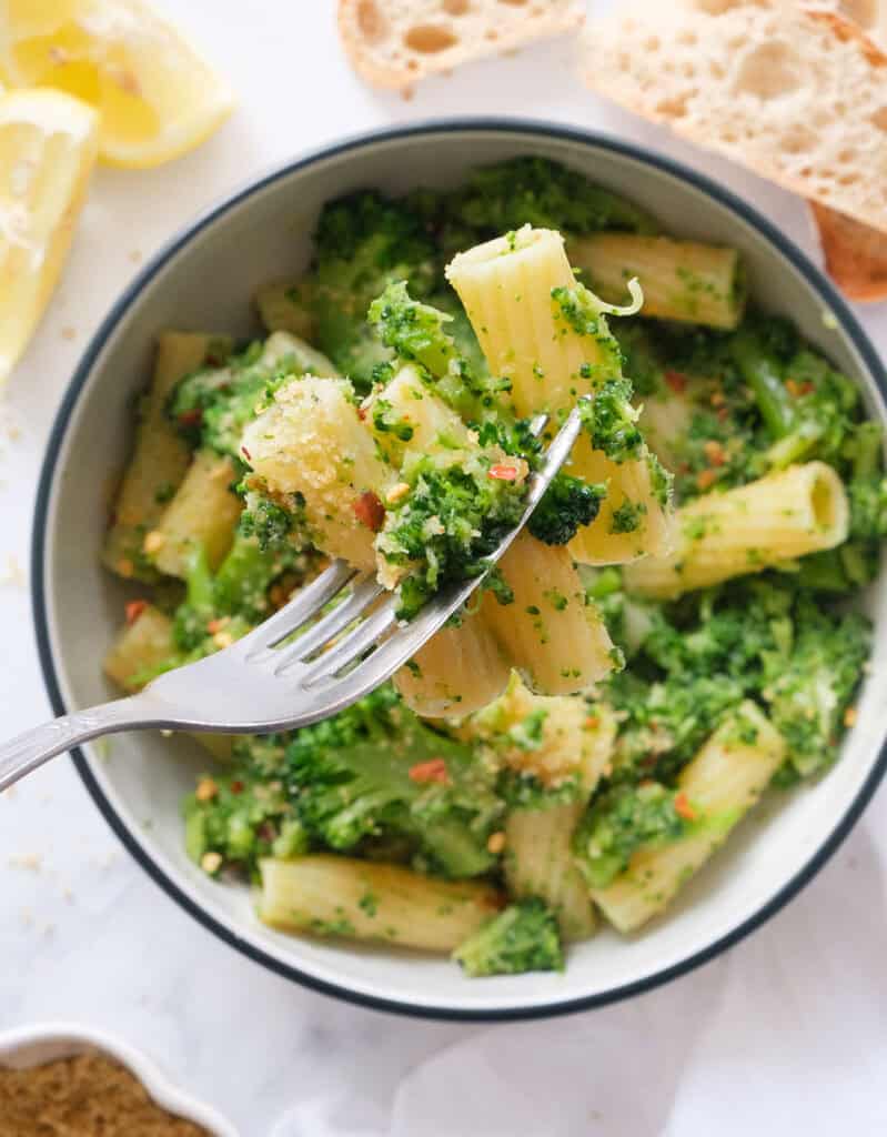 Close-up of a fork full of pasta with broccoli.