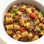 A white bowl full of pasta with lentils.