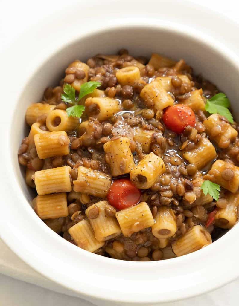 A white bowl full of pasta with lentils.