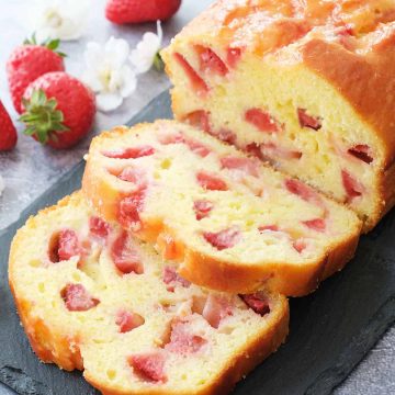 Strawberry bread cut into slices on a black slate tray.