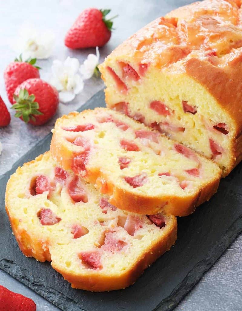 Strawberry bread cut into slices on a black slate tray.