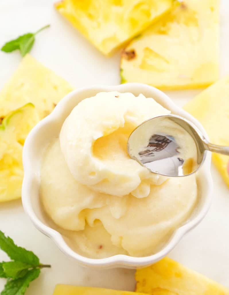 Close-up of some pineapple sorbet in a white bowl.
