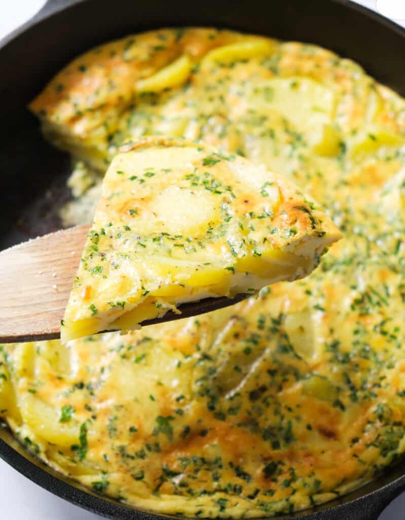 A slice of potato frittata with herbs.