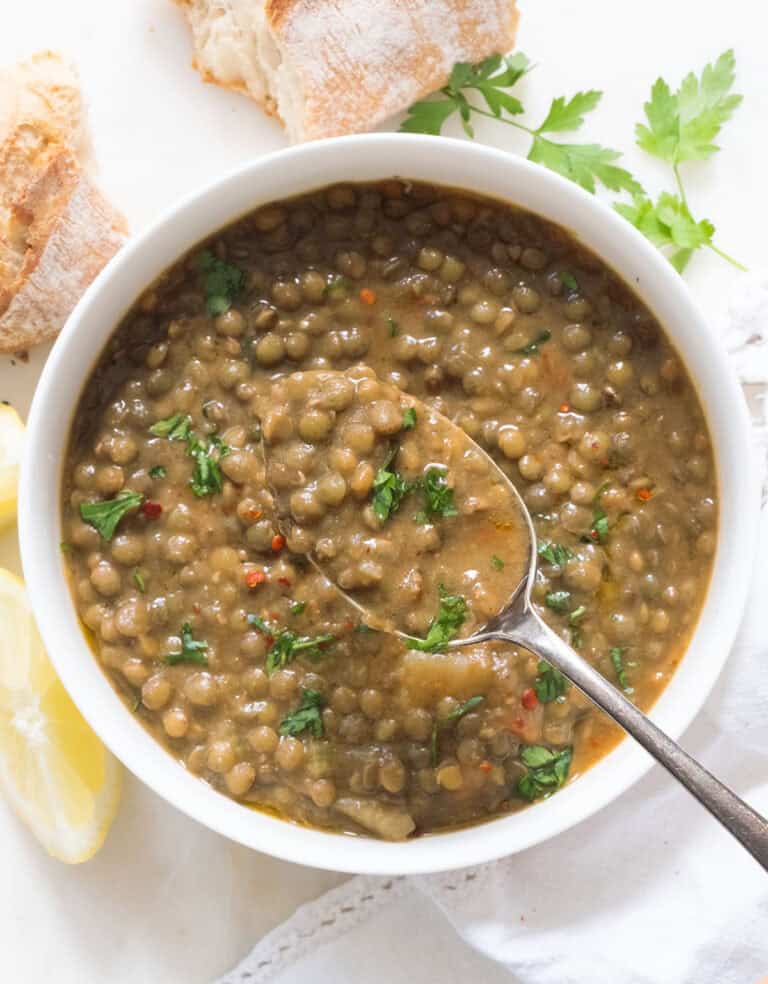Green lentil soup recipe served in a white bowl.