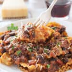 Close-up of a white plate full of pasta with black bean ragu'.