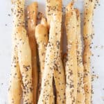 Close-up of a bunch of crusty seeded breadsticks.
