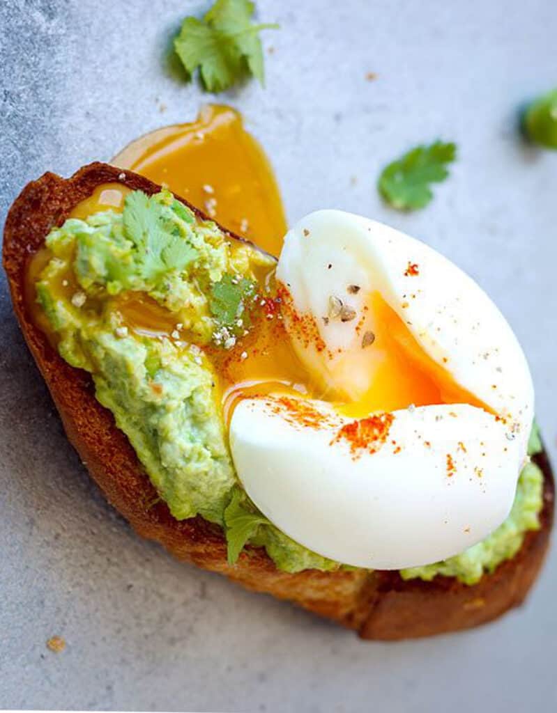 Close-up of a poached egg on mashed peas and toast.