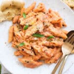 Tomato and ricotta pasta on a white plate.