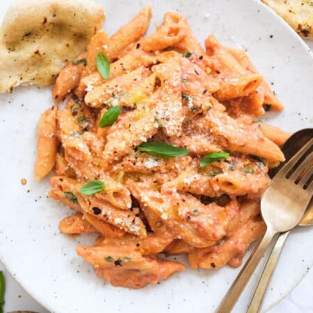 Tomato and ricotta pasta on a white plate.