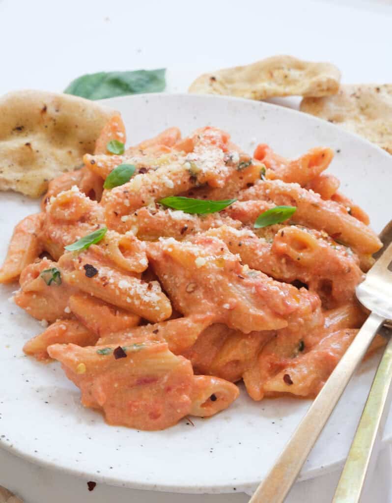 Close-up os fome tomato ricotta pasta on a white plate.