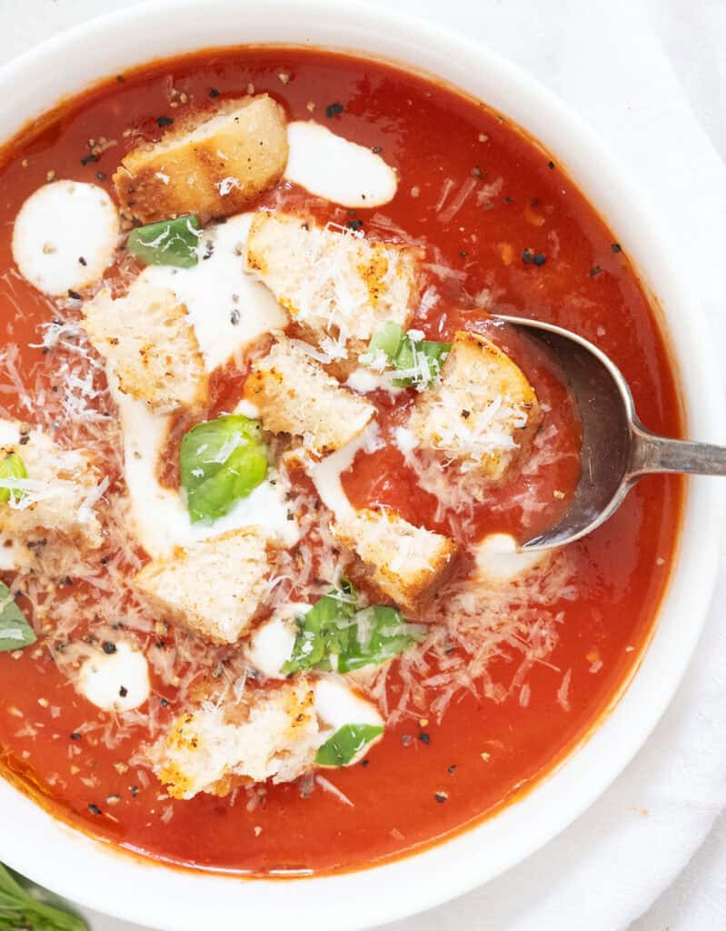 A white bowl full of easy homemade tomato soup with croutons.