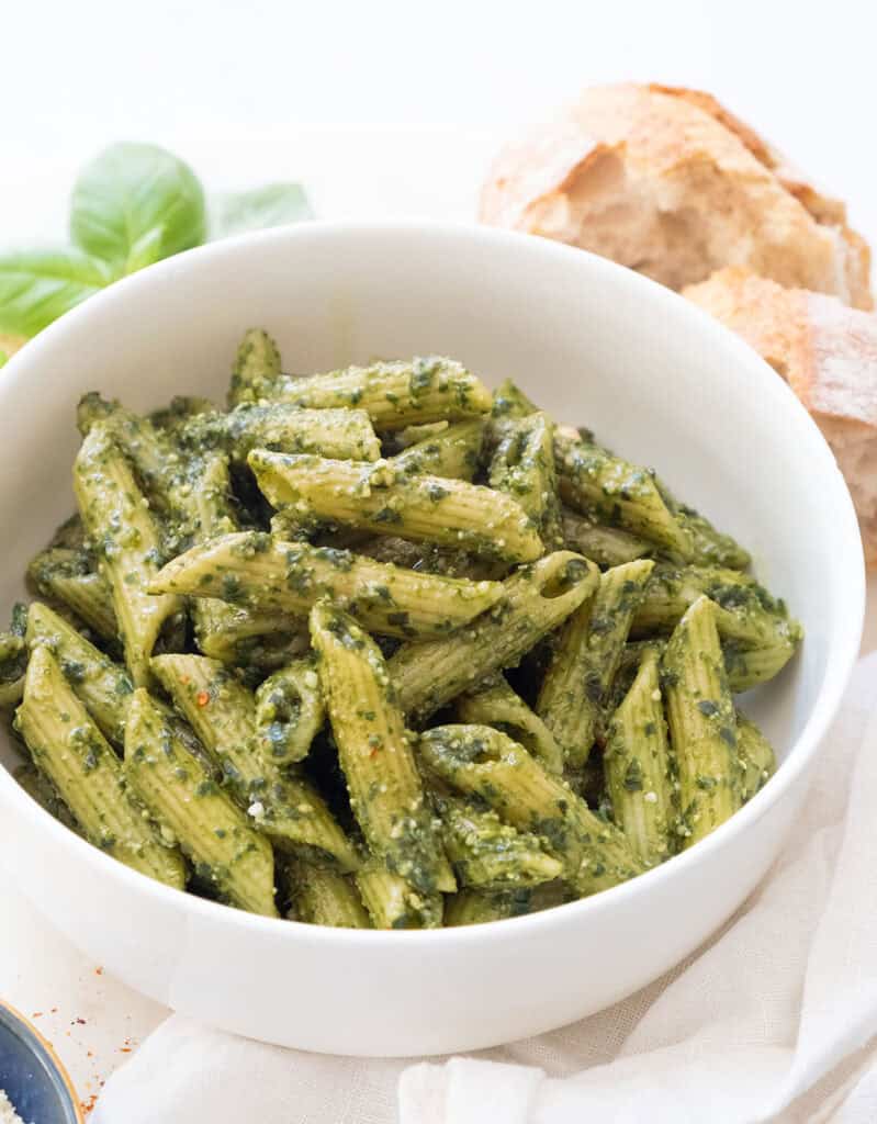 Penne with pesto in a white bowl.