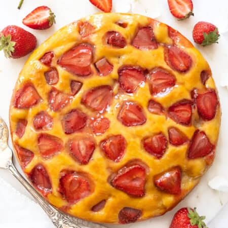 Top view of a strawberry ricotta cake on a white background.