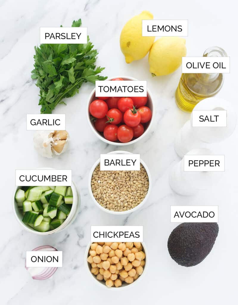 The ingredients to make the barley salad are arranged over a white background.